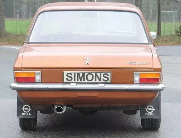 Achteraanzicht van een bruine Opel Ascona A 1.6, 1.9 met chromen bumper, achterlichten en kentekenplaat met de belettering Simons. Onder het voertuig is een Simons sportuitlaat van gealuminiseerd staal te zien met een ovale uitlaat van 70 / 90mm.