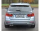 Achteraanzicht van een zilverkleurige BMW F30 Touring. Nummerplaat met "SIMONS" opschrift. Linksonder is het Simons roestvrijstalen sportuitlaatsysteem met 2 uitlaatpijpen (80 mm) zichtbaar. Rode achterlichten en bumper herkenbaar.